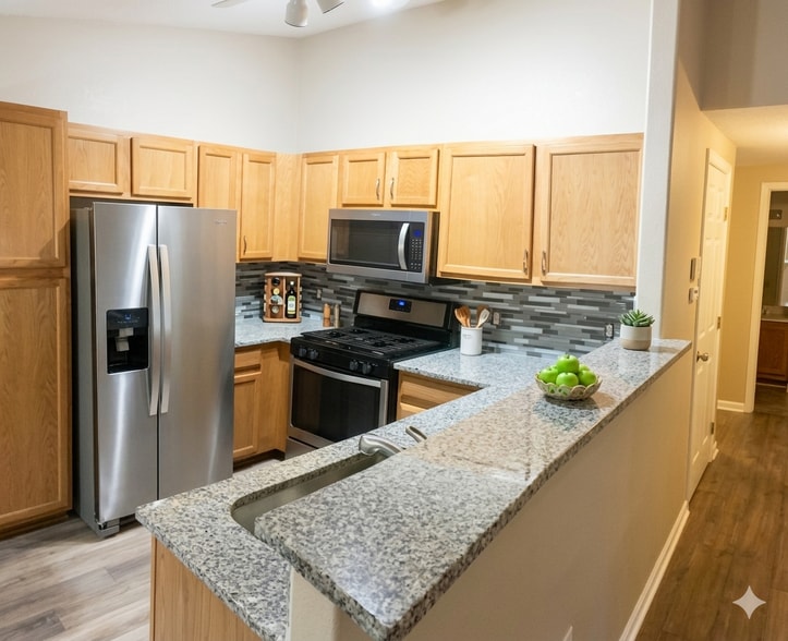 Lots of counter space on updated granite countertops and undermount stainless steel sink. Gas stove - 8427 Thunder Ridge Way #203