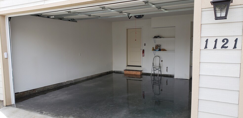 2 car garage with electric door opener, and storage shelving - 1121 Sundial Ln