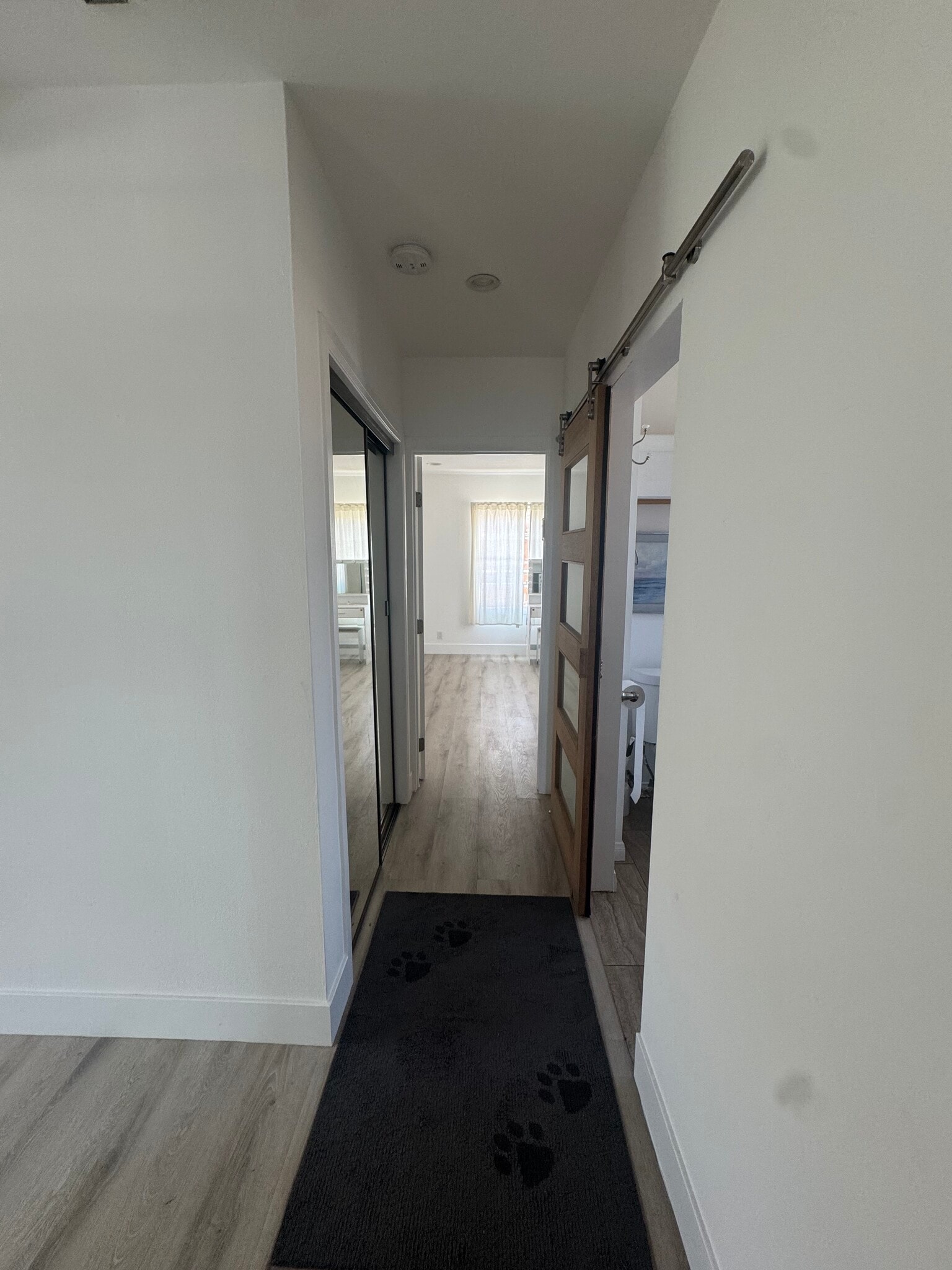 hallway to second room in the back of the unit and bathroom on the right with close on the left - 1339 S Mansfield Ave