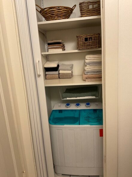 Bathroom closet has lots of storage and a small laundry unit - 825 Forest Ave