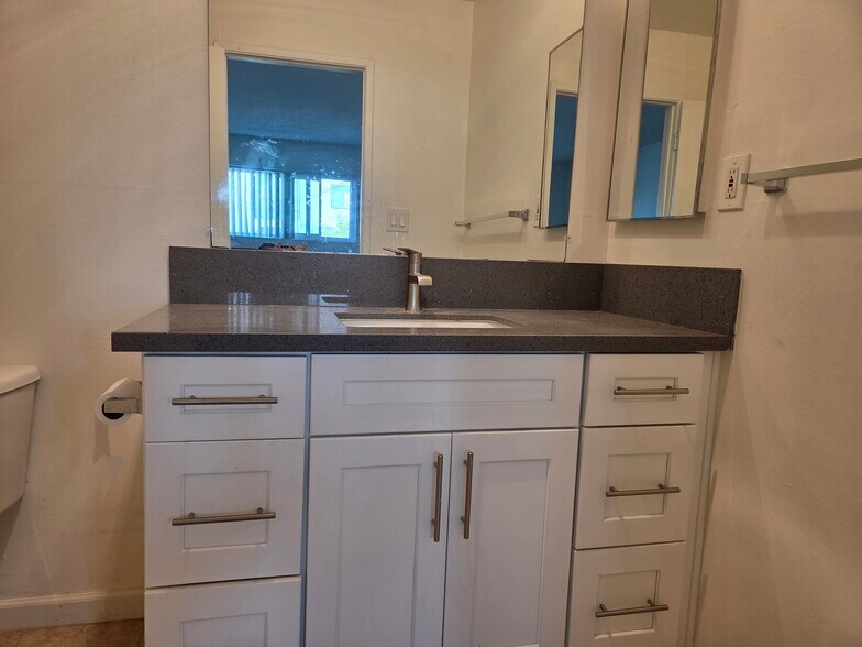 En suite bathroom with quartz countertop and Shaker cabinets - 3455 Elm Ave