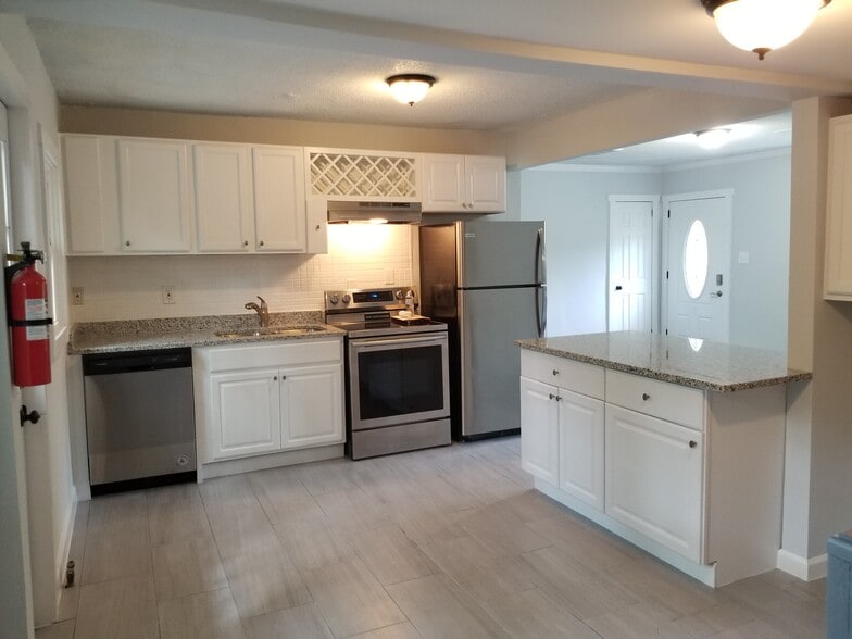 Kitchen with white cabinets, stainless appliances and granite counter tops. - 680 Tom Read Dr