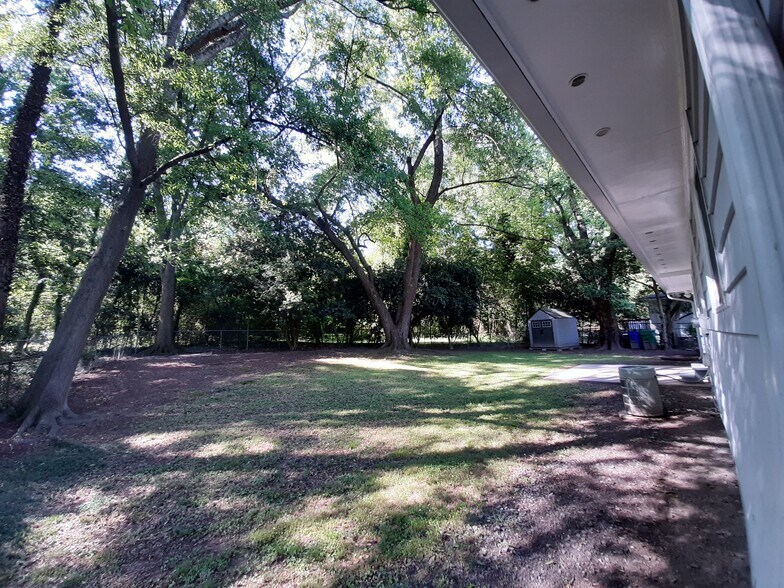 The large private backyard is surrounded by trees and a fence. Bonus security features include locking storm doors, backyard motion sensor lights, front-stoop dusk-to-dawn lighting, and a street light at the foot of the driveway. - 2955 Fantasy Ln