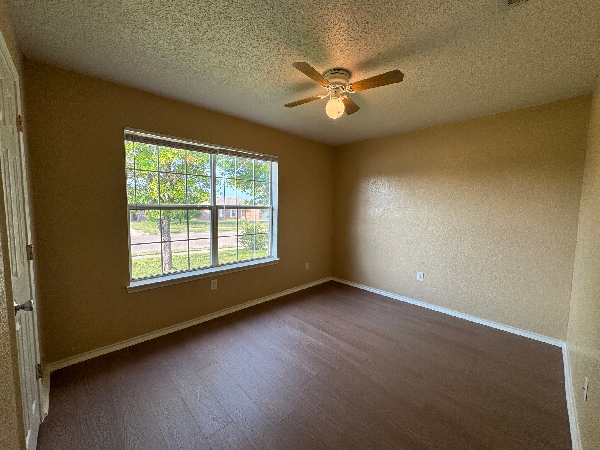 Quiet secondary bedroom with fresh paint, wood-look floors, and a new ceiling fan. - 2806 Maria Dr