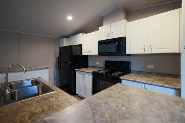 Kitchen including appliances: fridge, microwave, and oven. - 1225 Orizaba