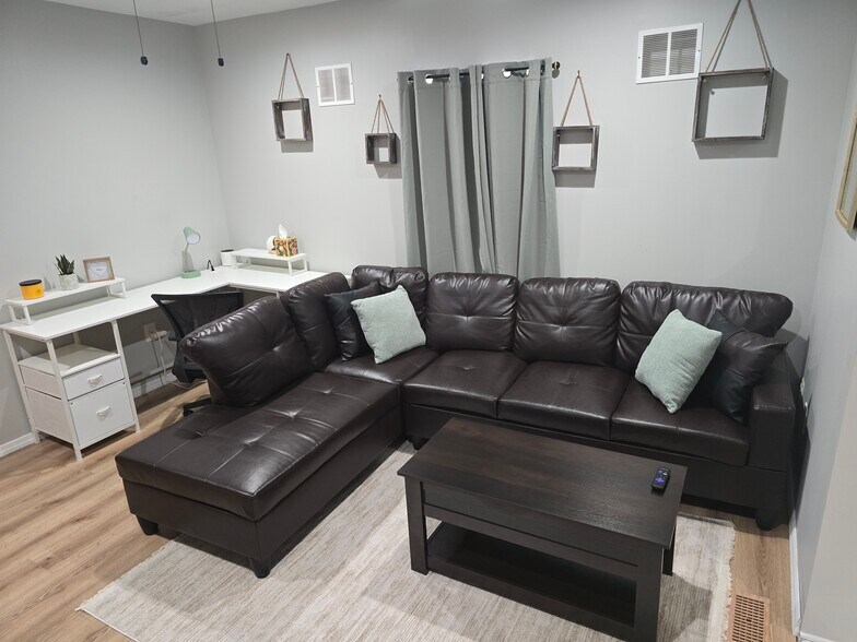 L-shaped couch in living room with lift top coffee table and desk area on the left - 510 North St