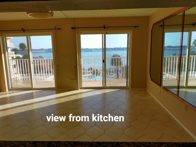 View from kitchen, overlooking living room and the water. - 7432 Sunshine Skyway Ln S