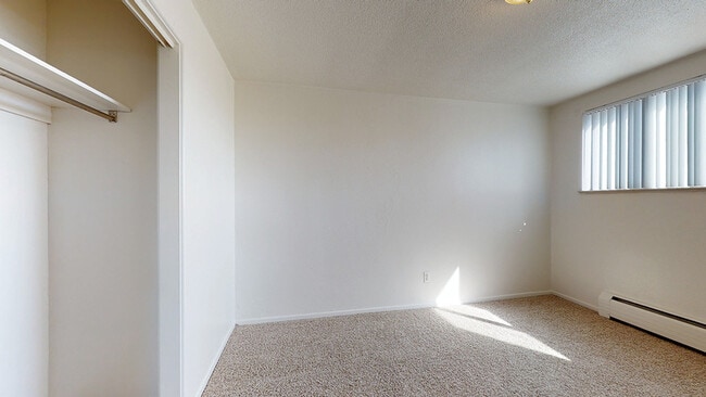 Experience comfort in this bright, airy bedroom designed for tranquility. - Melody Apartments