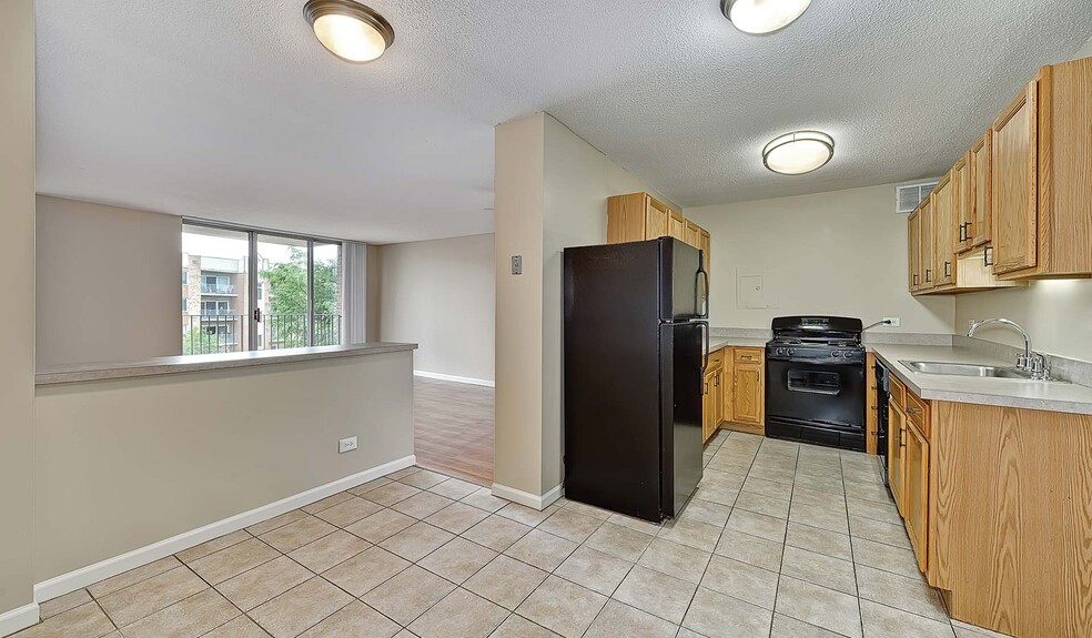 Select homes feature a modern kitchen with stainless steel appliances and a kitchen island - Yorktown Apartment Homes