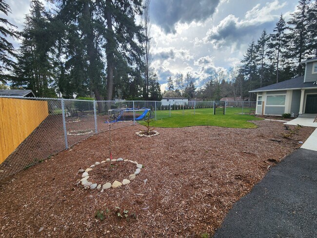 Front landscape with varieties of fruit trees & privacy fence & gate - 958 152nd St E