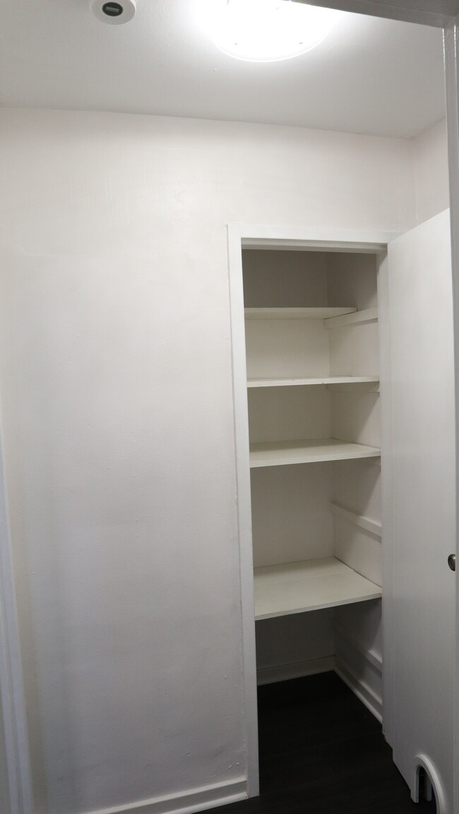 Hallway linen closet outside of the bathroom. (Notice the little opening to hide a cat's litter box) - 836 Thorn St