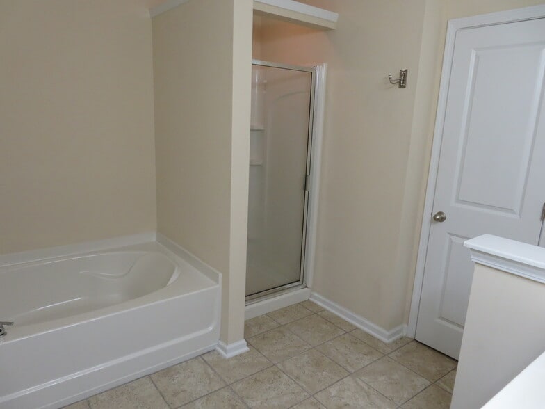 Master Bath garden bathtub, separate shower w built in shelves, linen closet & tile flooring - 2496 Stadium Dr