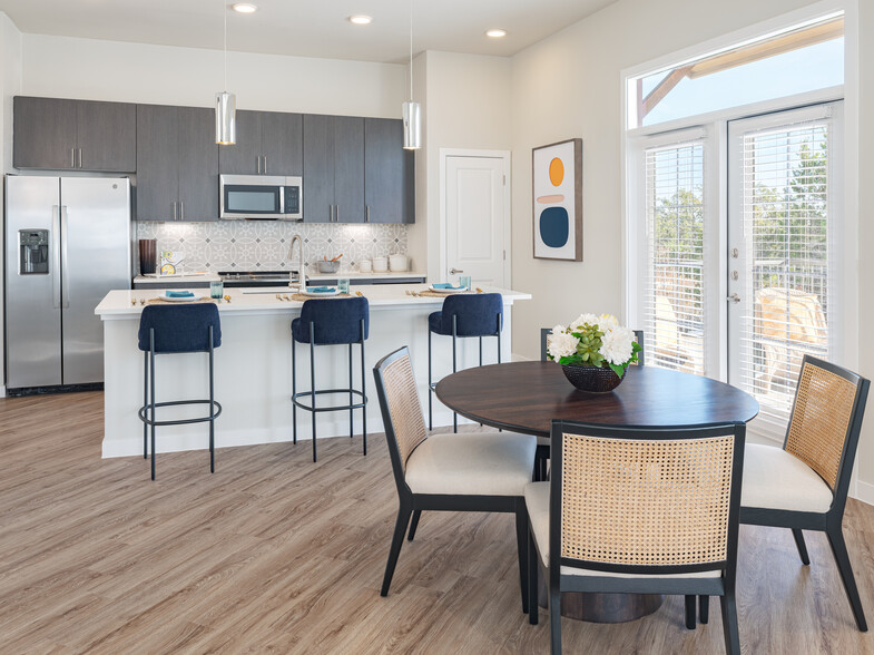 Kitchens with stainless steel appliances, wine fridges, quartz countertops, tile backsplash, and hard surface flooring - Avalon Townhomes at Bee Cave