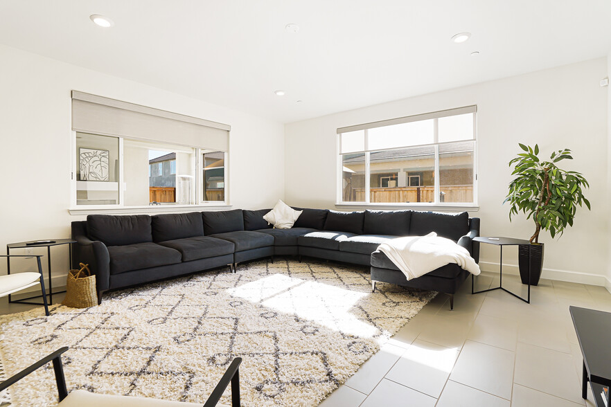 Large living room open to kitchen/dining area, & Hunter Douglas light filtering roller shades. - 5919 Lakestone Dr