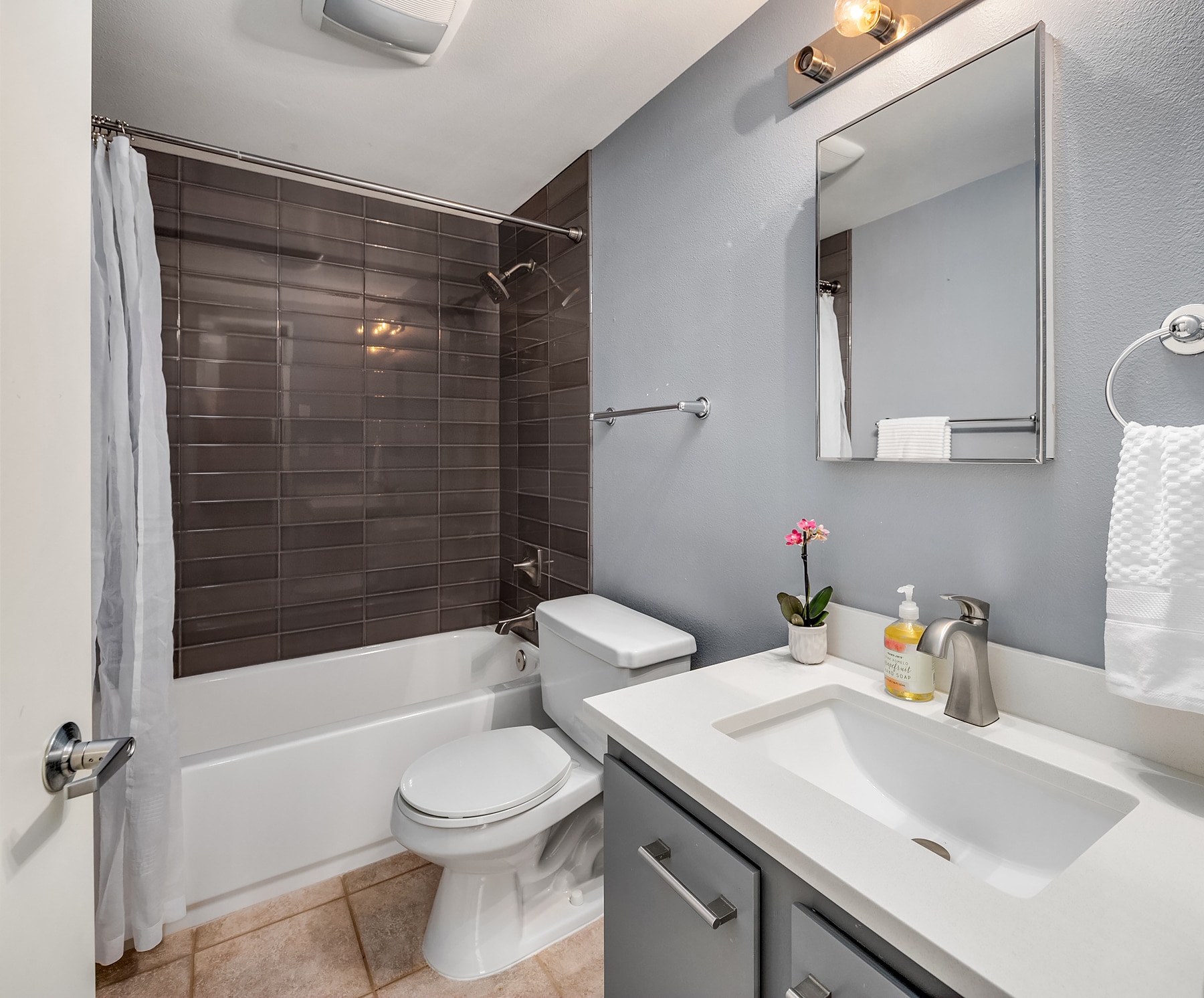 Bathroom updates include new stacked tile tub surround & new quartz counter, sink & faucet. - 7051 8th Ave NW