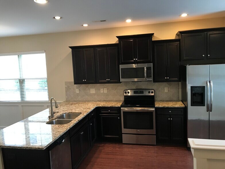 Kitchen with granite countertops, tile backsplash and stainless steel appliances - 6417 Swatner Drive
