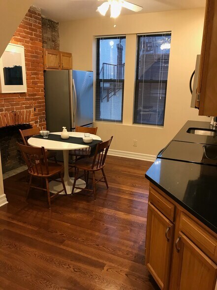 Large eat-in kitchen with dramatic brick wall - 5960 Alder St