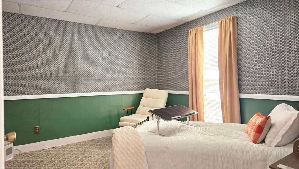 Furnished bedroom 1 view! Closet is available, and the rocking chair reclines plus has a foot rest! - 76 N Main St