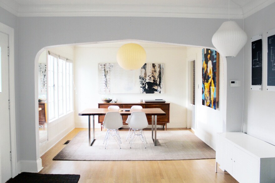 Light filled dining room with tall casement windows and translucent cellular window coverings throughout. Authentic George Nelson MCM lamp fixtures. - 2635 NE 30th Ave