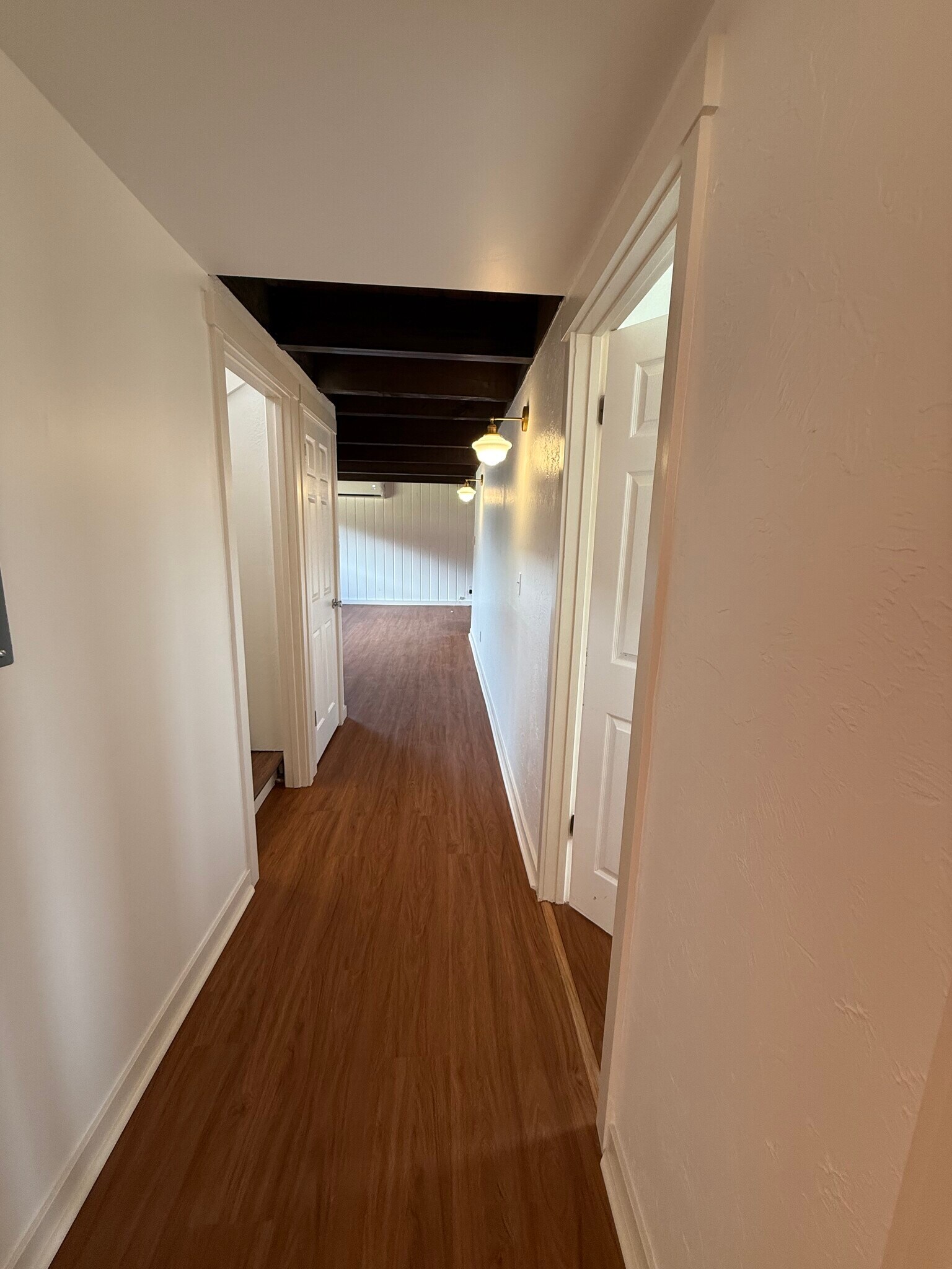 Hallway facing family room, downstairs bathroom, and stairs to front door - 13016 16th St NE