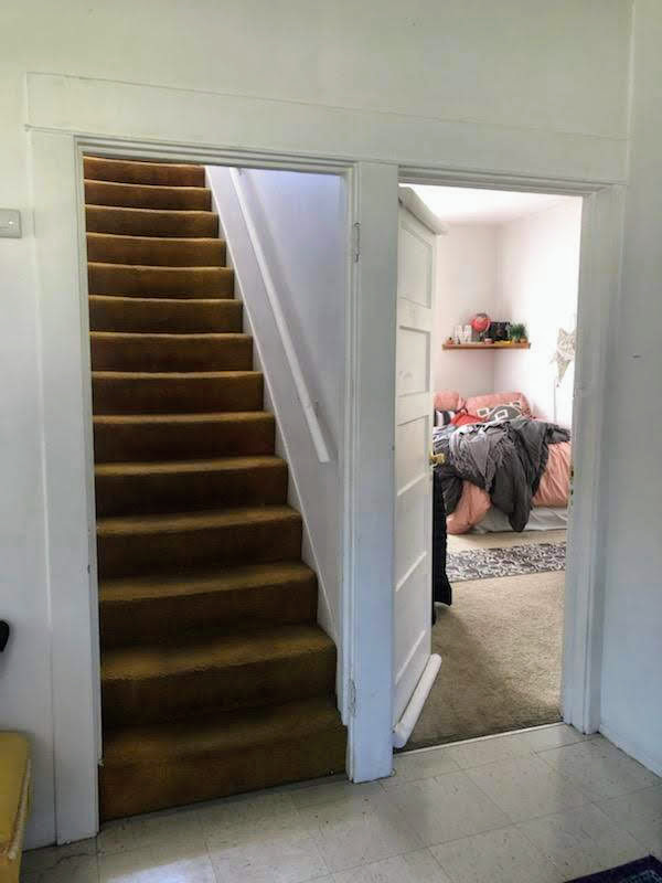 Stairway to upper-level two bedrooms and entry to bedroom off the kitchen area - 804 NW 29th St