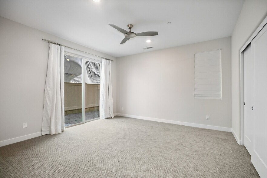 First floor bedroom with view to sliding door. Note: photo taken prior to finished landscape - 590 Catalonia