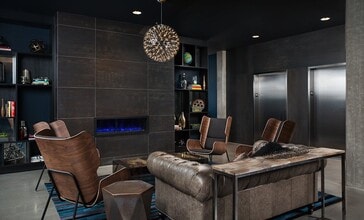 Stylish Resident Lounge with Leather Seating and Modern Fireplace at Pike Motorworks - Pike Motorworks