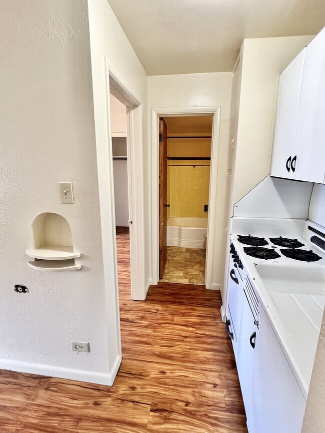 Step into a welcoming kitchen with modern design and warm wooden floors. - Hillside Apartments