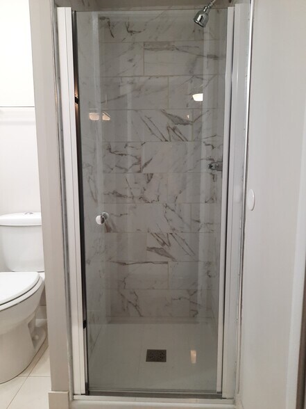 Walk-in shower in ensuite bathroom with calacatta gold ceramic tile - 434 Clinton Pl