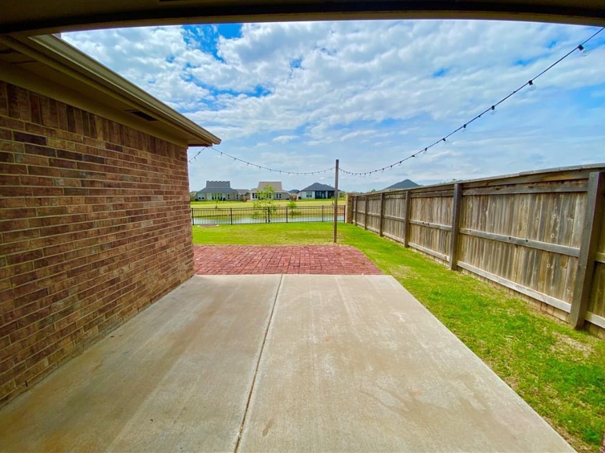 Backyard with extended pavers, outdoor lights, and pond view - 2452 NW 190th St