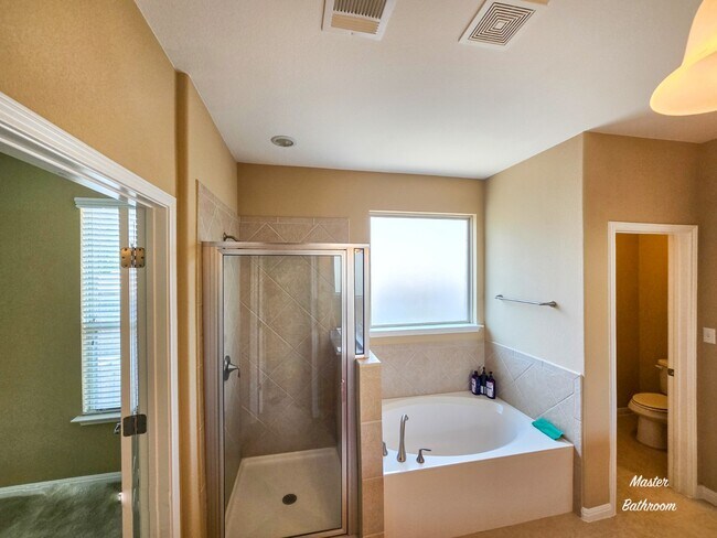 The master bathroom offers a spa-like retreat with a luxurious soaking tub and a walk-in shower - 301 Silver Trl