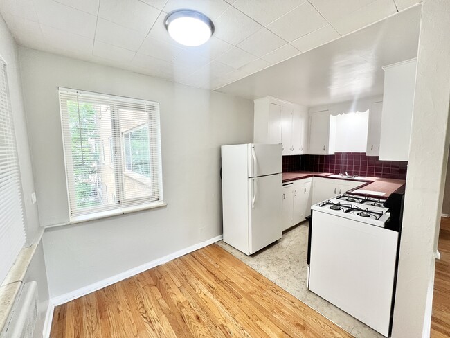 Experience the charm of this bright kitchen, perfect for culinary adventures. - The Birney Apartments