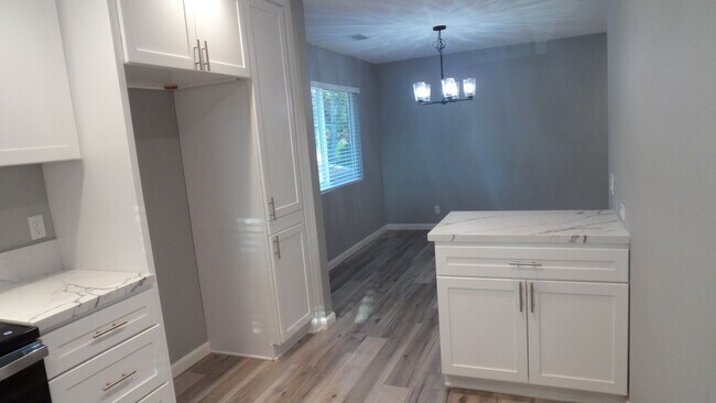 Building Photo - REMODELED 2BR; 1BA end unit condo w/ 1 car garage & 1 parking space