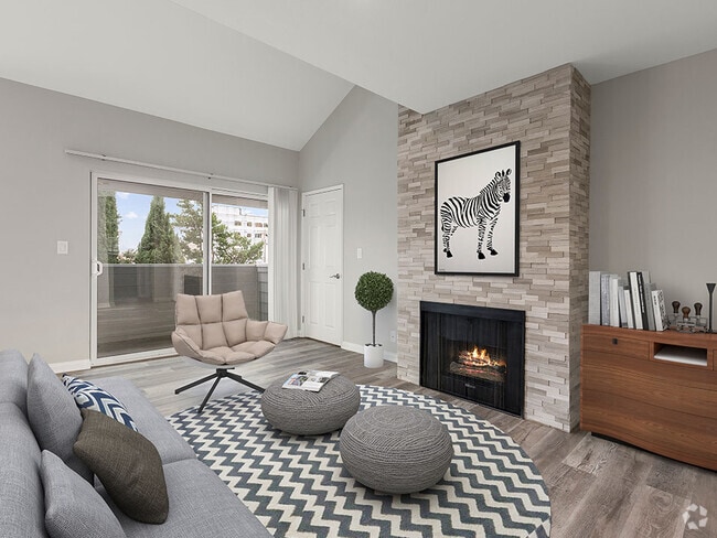 Living room with hardwood floors and stone wall accented fireplace. - Vinton Apartments