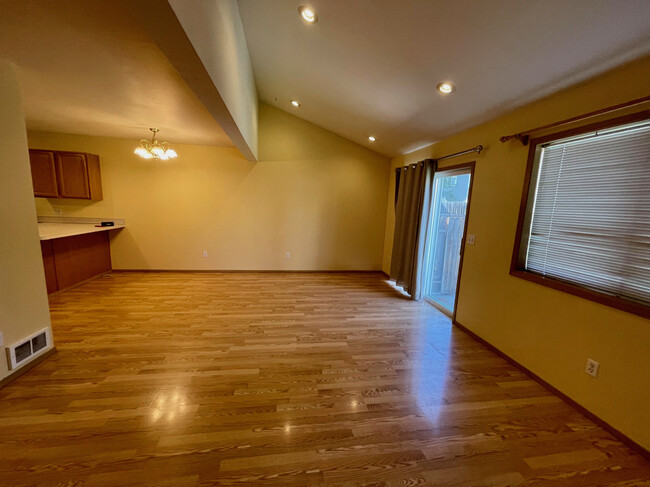 Dining area and vaulted ceiling. Kitchen island/bar on left. - 290 NW Clay Ct