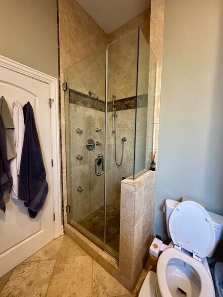 En suite bathroom with travertine tile, body sprays, and tub - 2651 W Haddon Ave