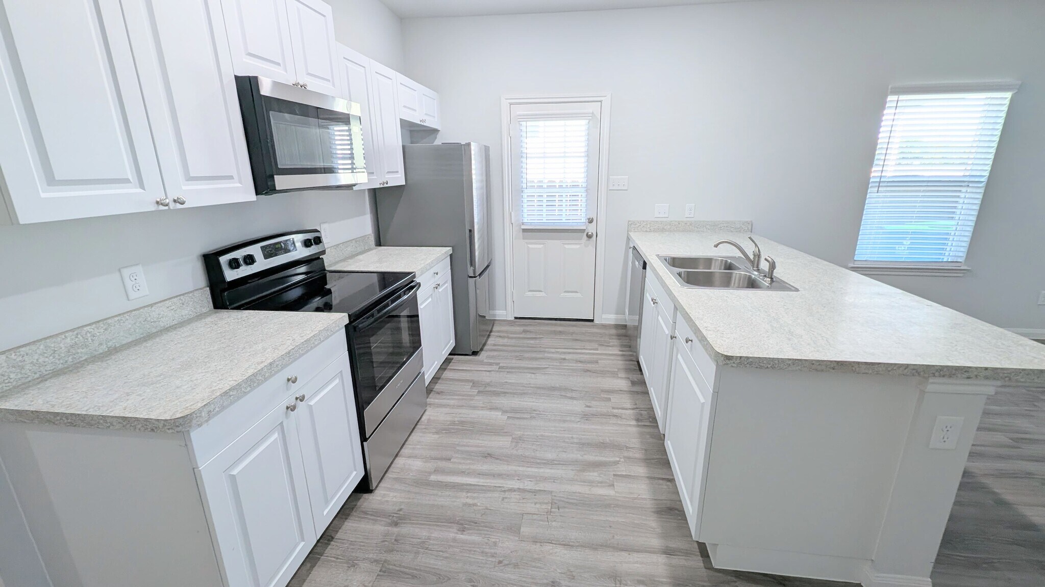 Large galley kitchen with new appliances including stove/oven, microwave, fridge, and dishwasher. - 13218 HP Johnson St