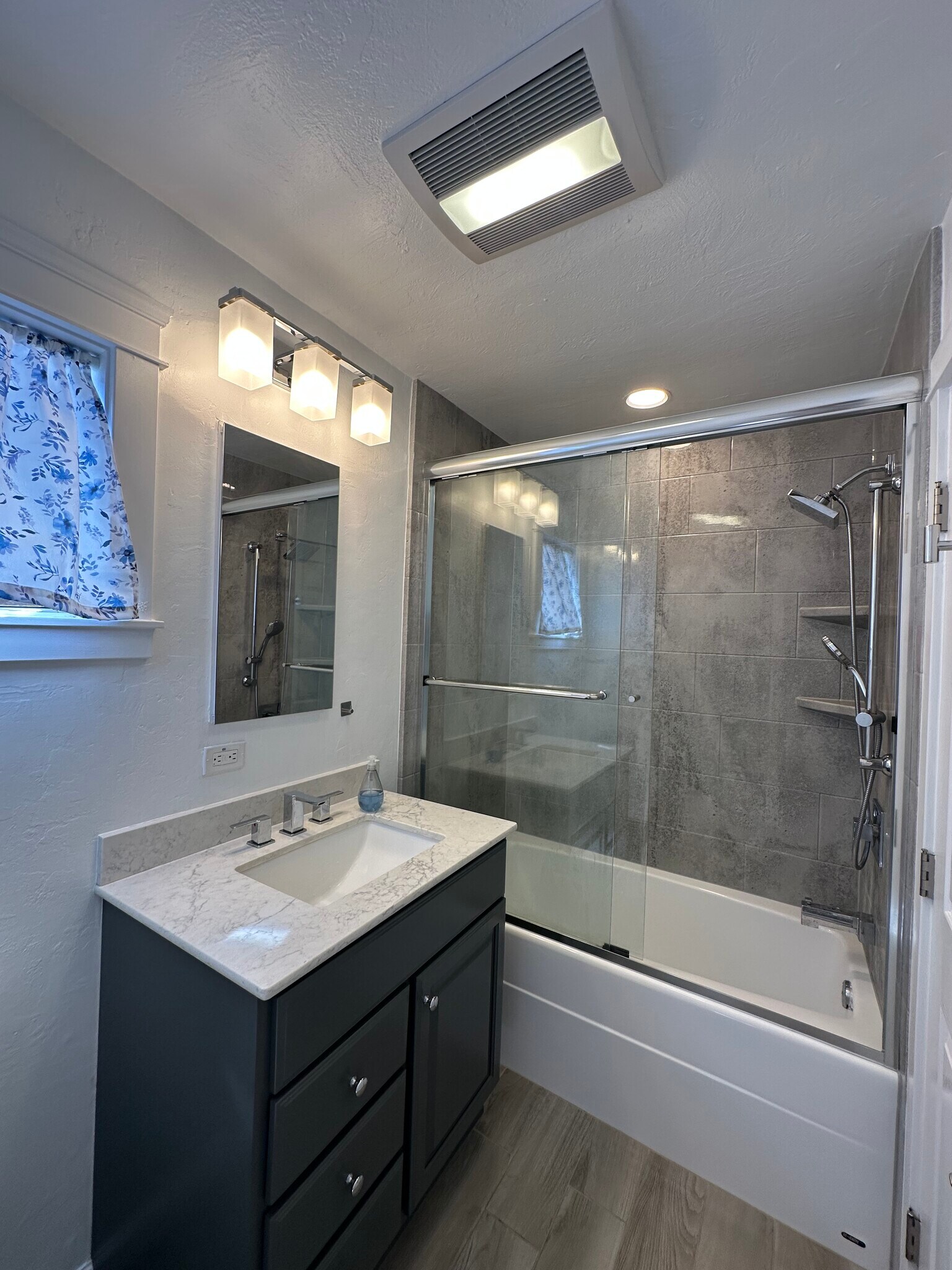 Stylish bath with glass-enclosed shower/tub combo, upgraded vanity & fixtures. - 721 15th St