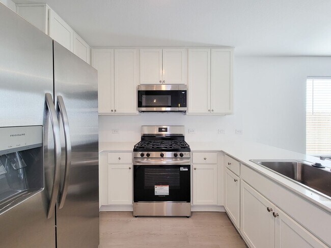 Building Photo - This single-level home showcases a spacious open floorplan shared between the kitchen, dining are...