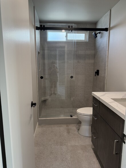 Custom glass shower doors. LED mirror over vanity. Shared bathroom for secondary bathrooms and publ - 209 39th St