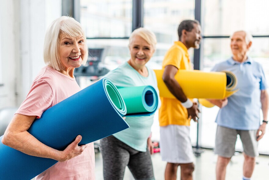 Men and woman with yoga mats - The Summerfield 62+ Community