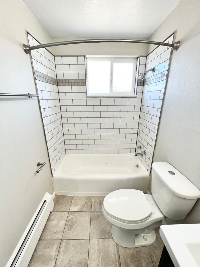 Experience the elegance of this modern bathroom, featuring sleek subway tiles and contemporary design. - Wadsworth Station West