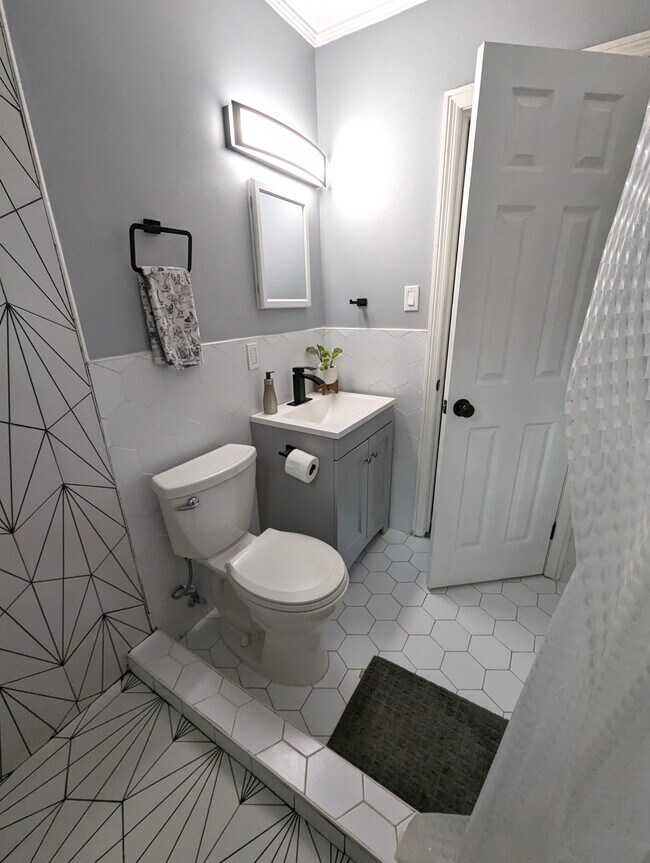 The bathroom is completely updated with custom tile work a rain shower and modern fixtures. - 4107 Crane St