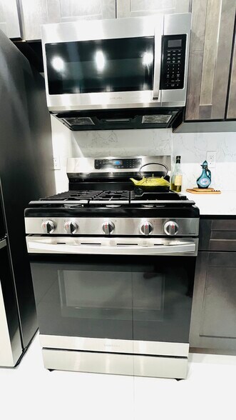 New kitchen With stainless steel refrigerator, dishwasher, microwave, and stove. Garbage disposal - 6600 Warner Ave