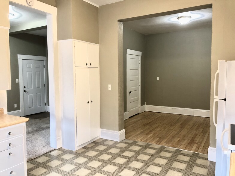 from kitchen into living area (left) and bedroom (right, hardwood) - 108 King St