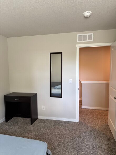 Guest room 1 with full length mirror and desk - 4521 SE Ember Ln