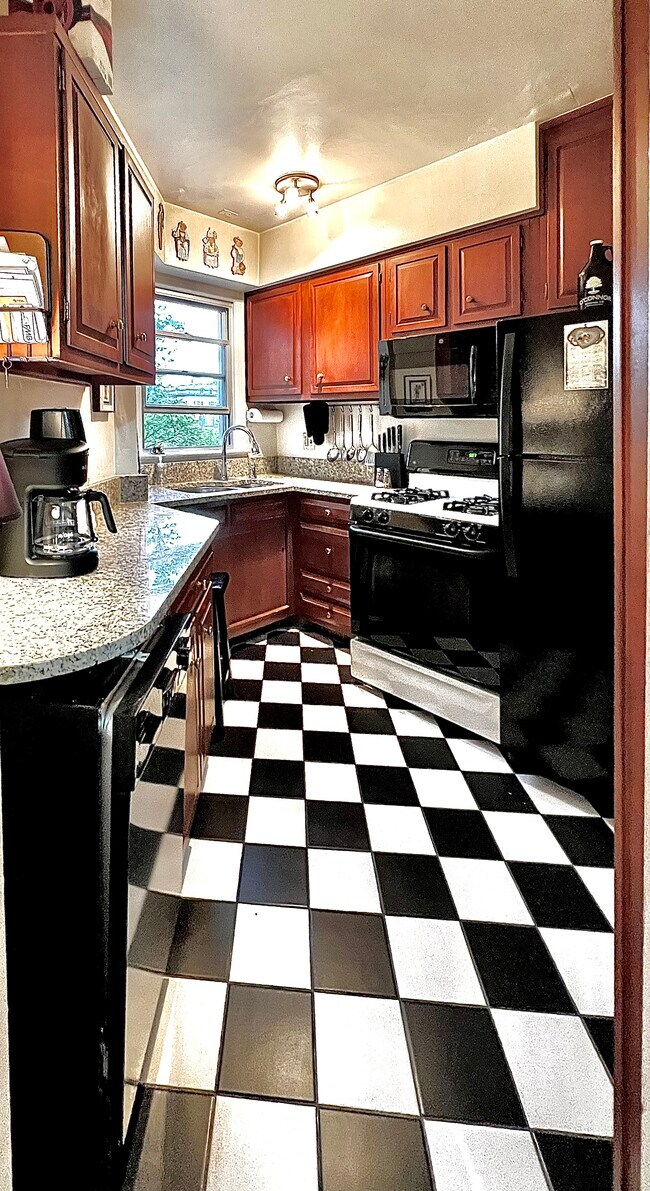 Kitchen with hardwood cabinets, marble countertops and new appliances. - 2500 Q St NW