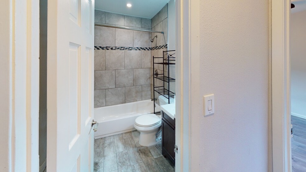 Light and airy bathroom with classic tile details and a tiled shower for a clean, modern look. - 5917 Little Creek Trl
