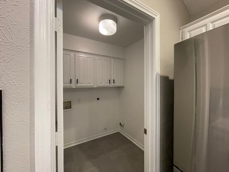 Full size washer dry laundry room just off the kitchen with additional storage space. - 812 Via Madonna