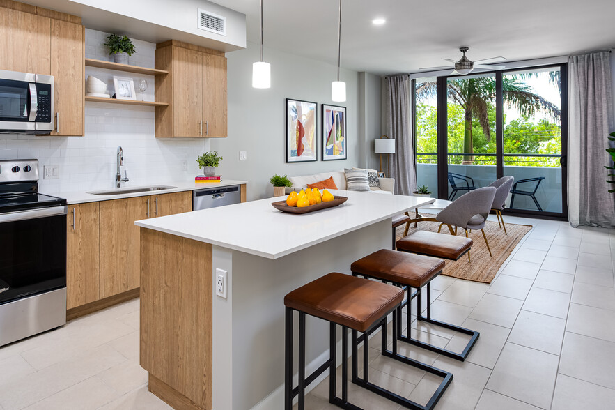 Open concept kitchen with quartz countertop, island, stainless steel appliances and tile backsplash - Avalon Doral